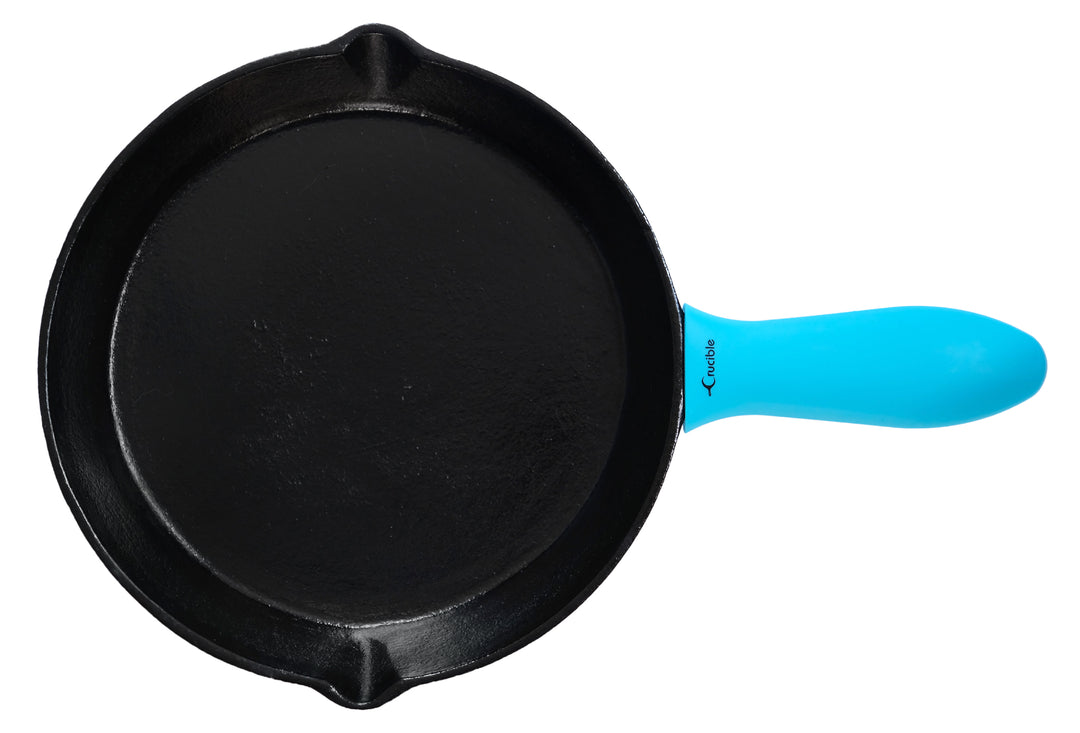 silicone potholder silicone sleeve pan handle holder grip handle cover in turquoise color on a cast iron skillet