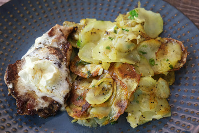 Côtelettes de porc avec pommes de terre crues frites et beurre à l'ail fouetté