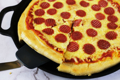 Kotitekoinen salamipannupizza valurautaisessa pizzapannussa