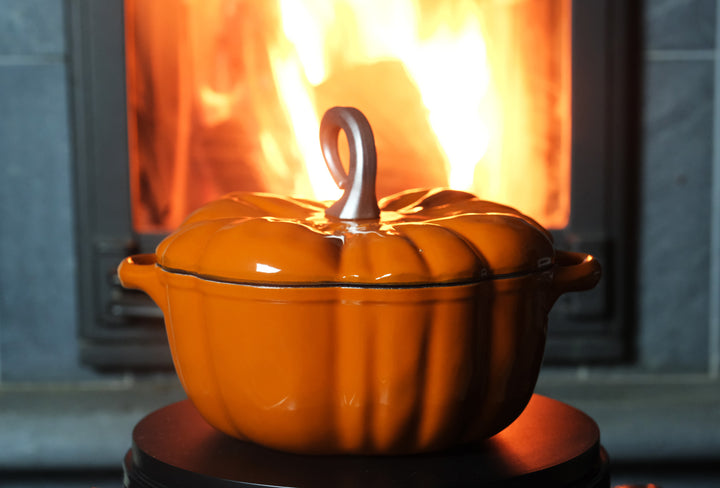 Enameled Cast Iron Pumpkin Pot in orange in front of the fire place