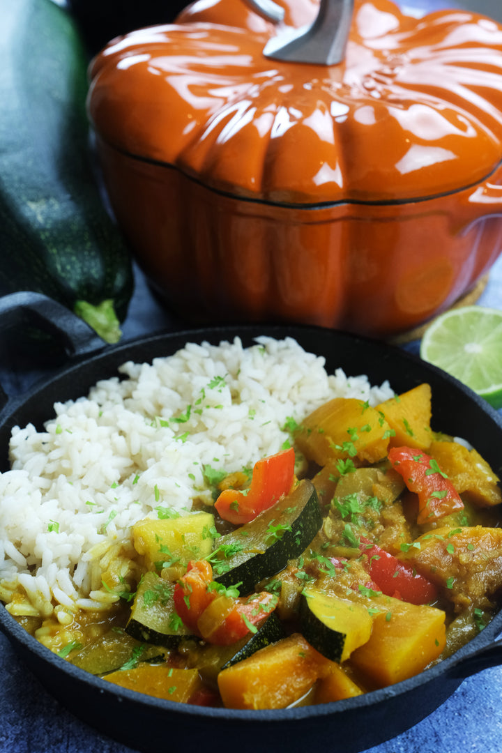 Rice and curry with Enameled Cast Iron Pumpkin Pot in orange in the background